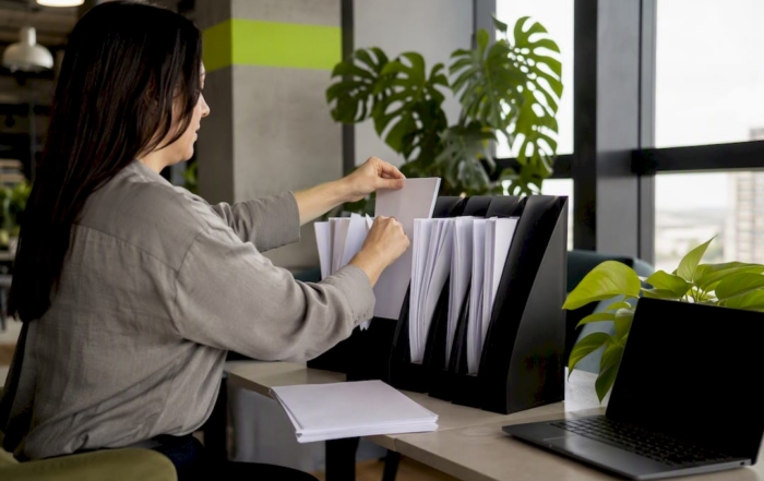 Hands filing wage compliance documents